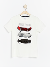 Hvid t-shirt med skateboard og vendbare paljetter