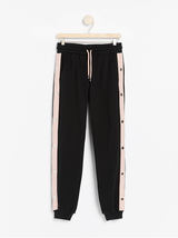Sort sweatpants med pink sidestriber og metal knapper